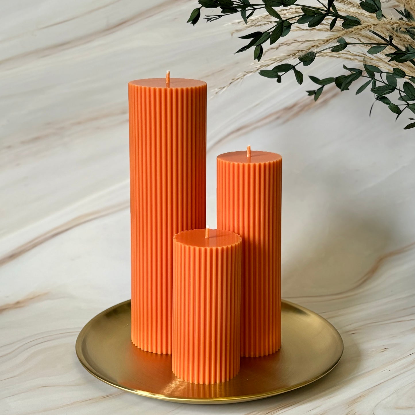 Orange Tall Ribbed Unscented Pillar Candles Unscented / Scented on a gold plate with flowers