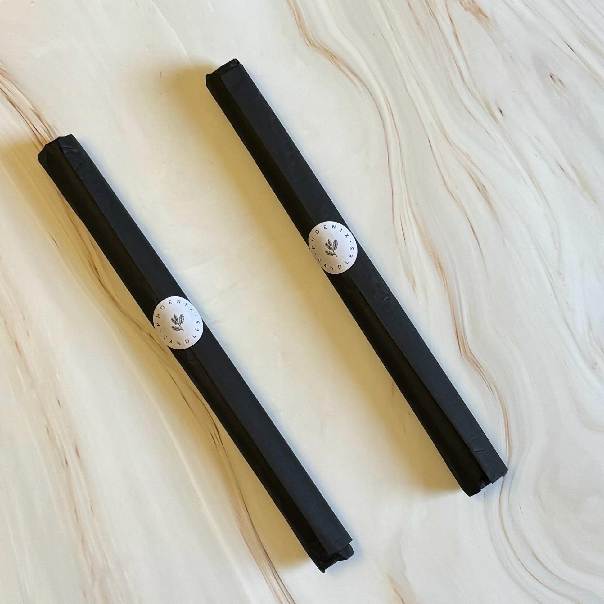 Two black rectangular objects with white circular labels are placed on a marble surface.