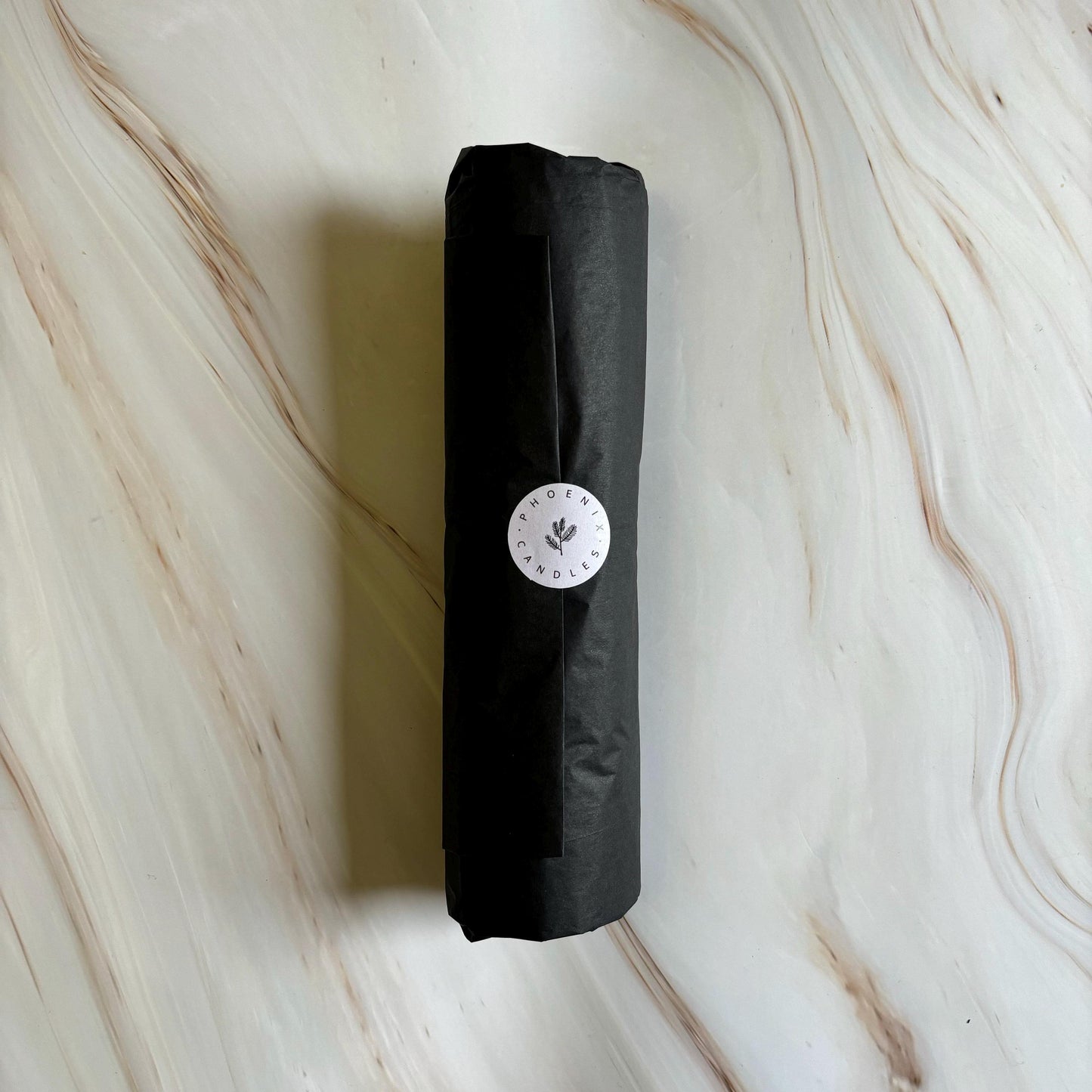 A black cylindrical object with a white circular label on it, placed on a marble surface.