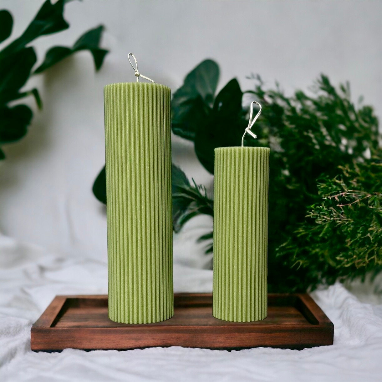 Green Orange Tall Ribbed Unscented Pillar Candles Unscented / Scented on a wooden home decor plate with flowers 